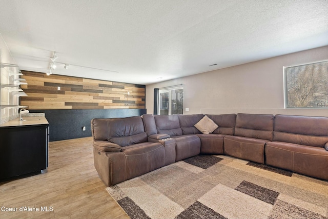 3206 N Lodgepole Rd, Coeur Dalene, ID 83815 - living room featuring wood walls, light wood finished floors, and an accent wall