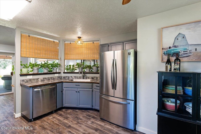 7315 W Lund St, Rathdrum, ID 83858 - kitchen with stainless steel appliances, gray cabinets, dark wood finished floors, dark countertops, and a textured ceiling