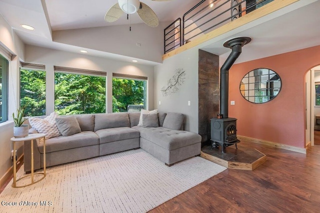 5653 W Racquet Rd, Rathdrum, ID 83858 - living area featuring wood finished floors, a wood stove, ceiling fan, arched walkways, and high vaulted ceiling