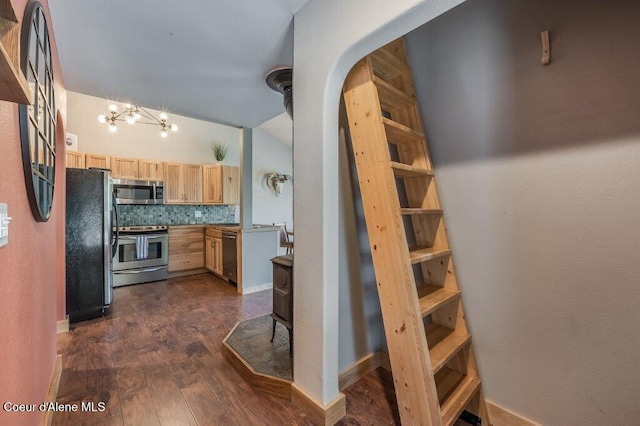 5653 W Racquet Rd, Rathdrum, ID 83858 - kitchen featuring appliances with stainless steel finishes, light brown cabinets, arched walkways, dark wood finished floors, and a chandelier