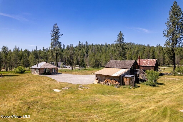 17320 E Perimeter Rd, Athol, ID 83801 - view of home's exterior with a view of trees, an outdoor structure, and a lawn