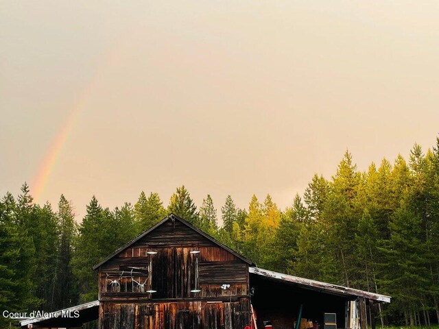 17320 E Perimeter Rd, Athol, ID 83801 - rear view of house with a wooded view, a barn, and an outdoor structure