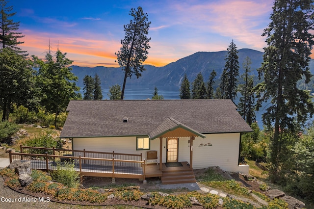 17544 E Arapaho Rd, Bayview, ID 83803 - view of front of home featuring roof with shingles and a deck with mountain view