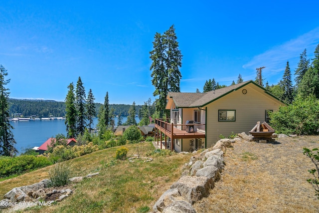 17544 E Arapaho Rd, Bayview, ID 83803 - view of yard featuring a deck with water view, a fire pit, and a wooded view
