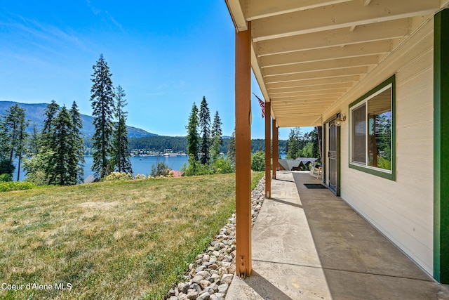 17544 E Arapaho Rd, Bayview, ID 83803 - view of grassy yard featuring a water and mountain view and a patio
