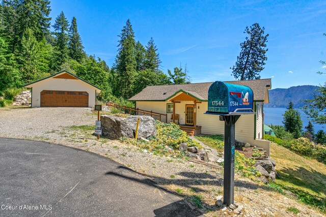 17544 E Arapaho Rd, Bayview, ID 83803 - view of front of house featuring a detached garage, an outbuilding, a mountain view, and a shingled roof