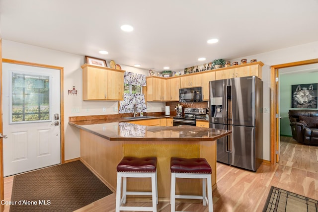 17544 E Arapaho Rd, Bayview, ID 83803 - kitchen with stainless steel appliances, a peninsula, light brown cabinetry, plenty of natural light, and recessed lighting