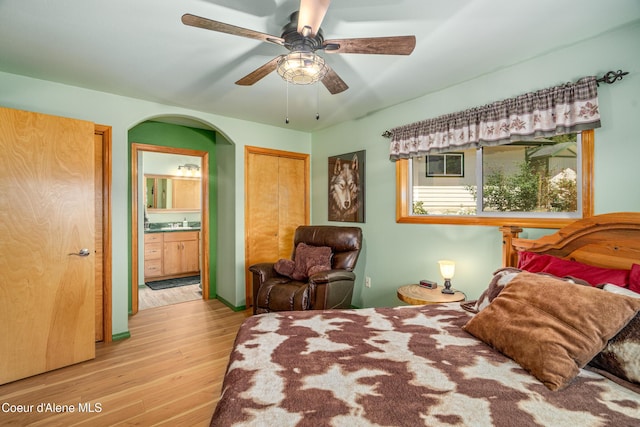 17544 E Arapaho Rd, Bayview, ID 83803 - bedroom with light wood-style flooring, ensuite bathroom, and ceiling fan