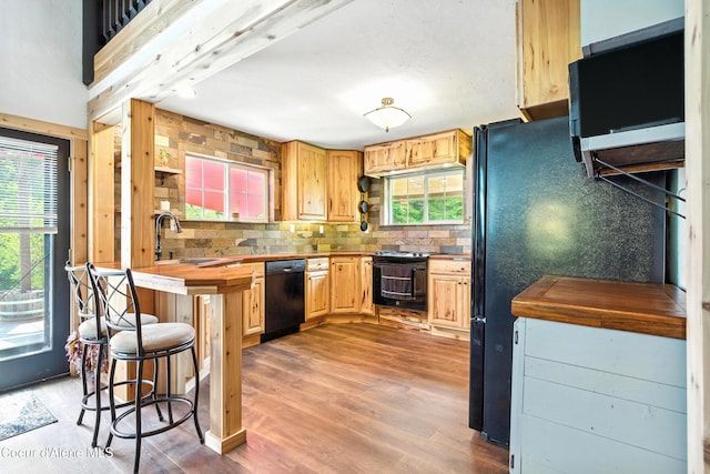 80 Half Cir, Priest River, ID 83856 - kitchen with black appliances, tasteful backsplash, a kitchen bar, wood finished floors, and wood counters