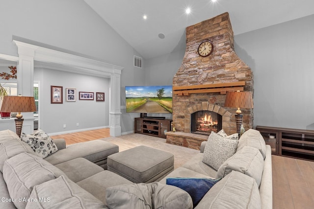 12155 N Yearling Cir, Hayden, ID 83835 - living room featuring ornate columns, high vaulted ceiling, light wood-style floors, a stone fireplace, and recessed lighting