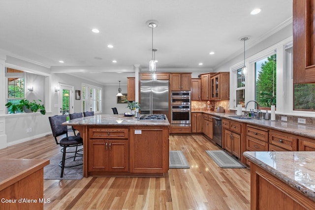 12155 N Yearling Cir, Hayden, ID 83835 - kitchen featuring stainless steel appliances, brown cabinets, light wood-style flooring, light stone countertops, and recessed lighting