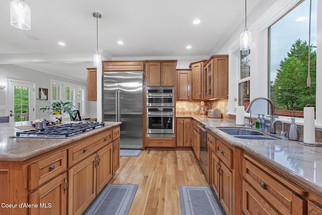 12155 N Yearling Cir, Hayden, ID 83835 - kitchen featuring stainless steel appliances, brown cabinetry, crown molding, light stone countertops, and decorative backsplash