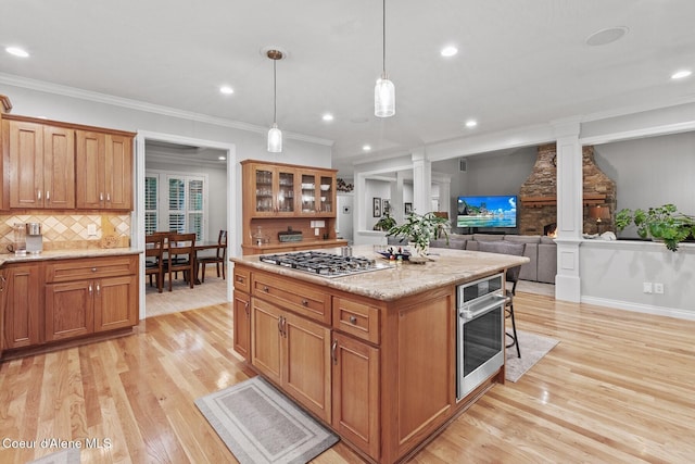 12155 N Yearling Cir, Hayden, ID 83835 - kitchen featuring appliances with stainless steel finishes, ornate columns, light wood-style floors, tasteful backsplash, and recessed lighting