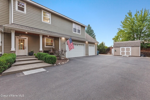 12155 N Yearling Cir, Hayden, ID 83835 - view of front of property featuring a storage shed, asphalt driveway, a shingled roof, and covered porch
