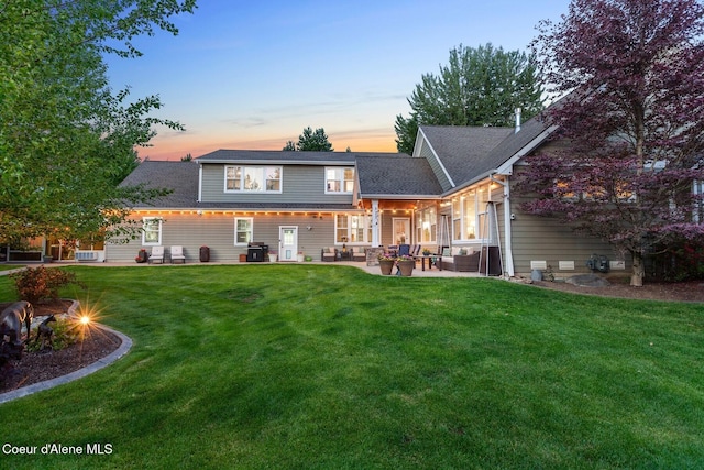 12155 N Yearling Cir, Hayden, ID 83835 - back of property with an outdoor living space with a fire pit, a patio area, and a lawn