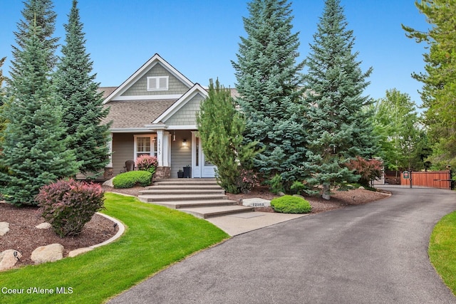 12155 N Yearling Cir, Hayden, ID 83835 - view of front of home with a gate, covered porch, a shingled roof, and a front lawn