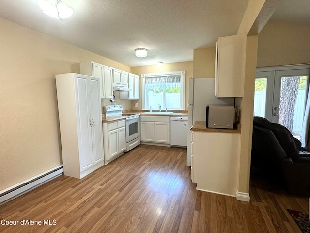 623 E Whispering Pines Ln # 3, Coeur Dalene, ID 83815 - kitchen featuring white appliances, a baseboard heating unit, wood finished floors, white cabinetry, and a textured ceiling