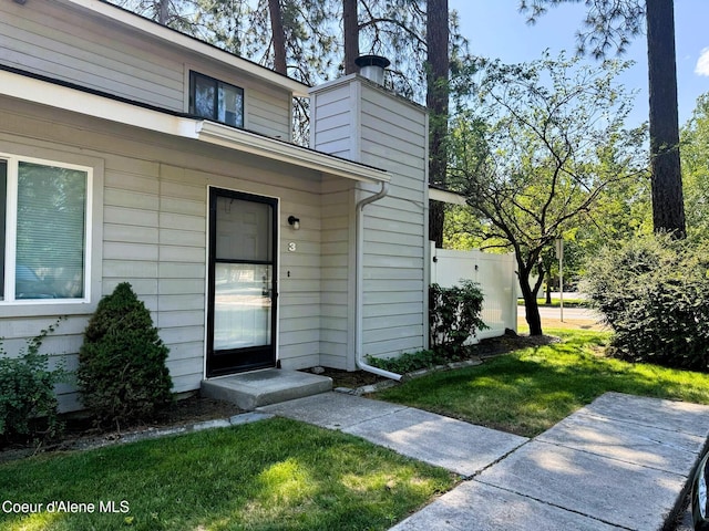 623 E Whispering Pines Ln # 3, Coeur Dalene, ID 83815 - doorway to property featuring a lawn and a chimney