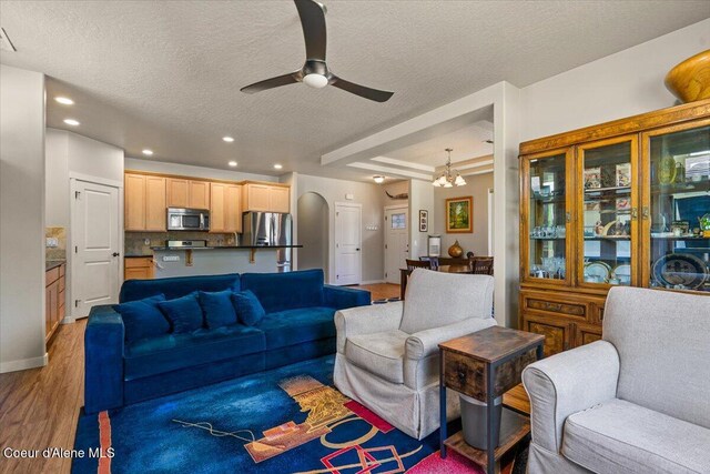 1232 W Grove Way, Coeur Dalene, ID 83815 - living area featuring ceiling fan, a textured ceiling, light wood finished floors, recessed lighting, and a chandelier