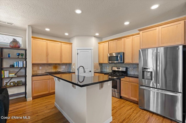 1232 W Grove Way, Coeur Dalene, ID 83815 - kitchen featuring stainless steel appliances, dark countertops, light wood-style floors, tasteful backsplash, and light brown cabinets