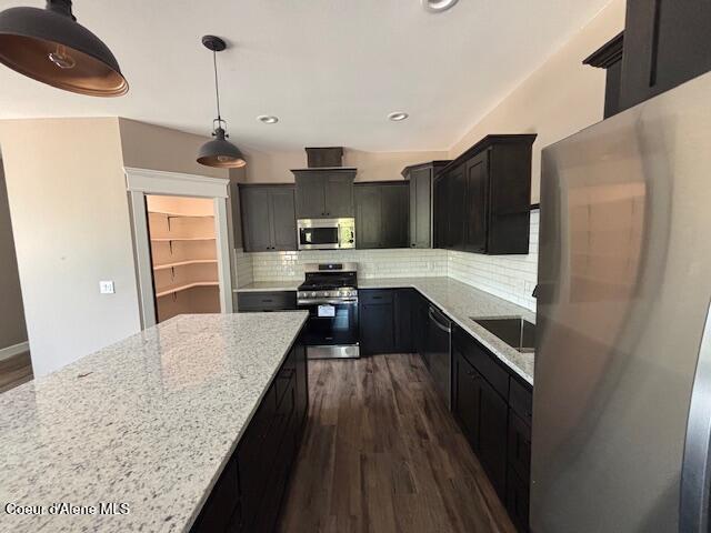 32926 N 10th Ave, Spirit Lake, ID 83869 - kitchen with stainless steel appliances, light stone countertops, dark wood-style floors, decorative backsplash, and recessed lighting