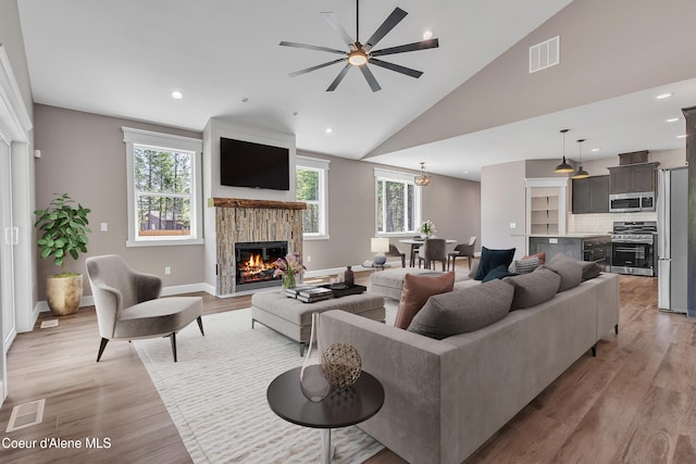 32926 N 10th Ave, Spirit Lake, ID 83869 - living area featuring a glass covered fireplace, light wood-type flooring, a ceiling fan, high vaulted ceiling, and recessed lighting