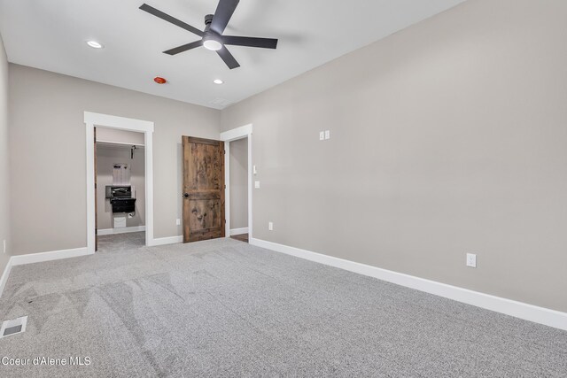 32926 N 10th Ave, Spirit Lake, ID 83869 - unfurnished bedroom with a walk in closet, carpet flooring, recessed lighting, and ceiling fan