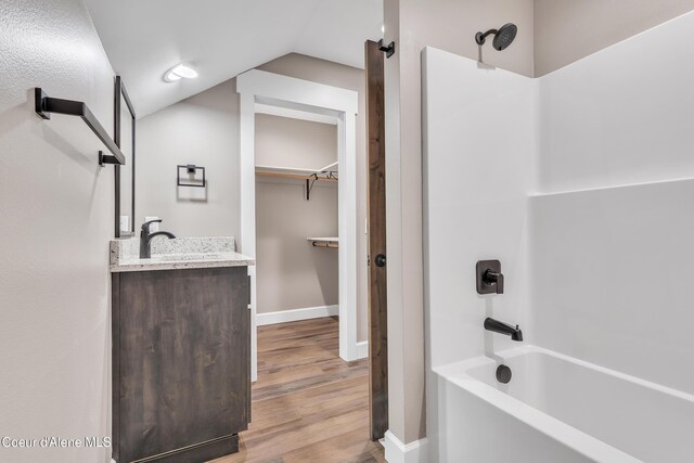 32926 N 10th Ave, Spirit Lake, ID 83869 - full bathroom with shower / washtub combination, vanity, wood finished floors, vaulted ceiling, and a walk in closet
