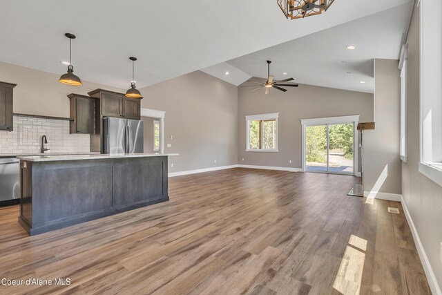 32926 N 10th Ave, Spirit Lake, ID 83869 - kitchen with appliances with stainless steel finishes, light countertops, dark brown cabinetry, light wood finished floors, and a center island