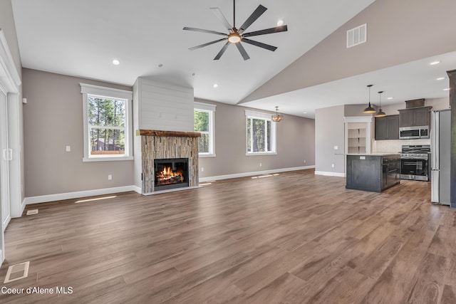 32926 N 10th Ave, Spirit Lake, ID 83869 - unfurnished living room with a glass covered fireplace, a ceiling fan, light wood finished floors, high vaulted ceiling, and recessed lighting
