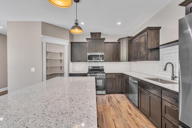 32926 N 10th Ave, Spirit Lake, ID 83869 - kitchen featuring stainless steel appliances, light wood-style floors, dark brown cabinets, light stone countertops, and recessed lighting