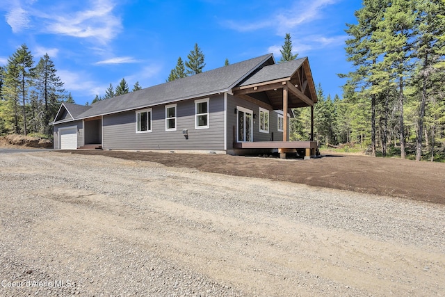 32926 N 10th Ave, Spirit Lake, ID 83869 - view of front facade featuring dirt driveway, a garage, a shingled roof, and crawl space