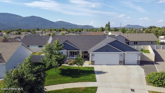 6487 W Covenant St, Rathdrum, ID 83858 - view of front of home with an attached garage, stone siding, driveway, and a residential view