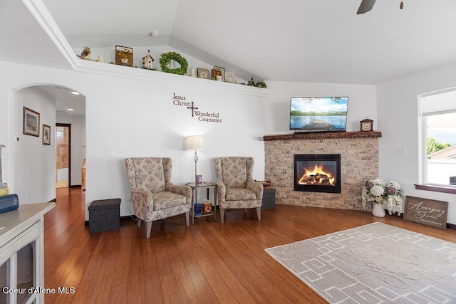 6487 W Covenant St, Rathdrum, ID 83858 - living area with arched walkways, wood finished floors, a fireplace, a ceiling fan, and vaulted ceiling