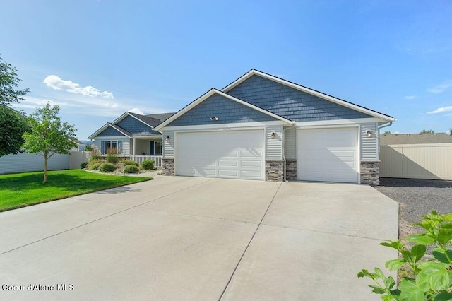 6487 W Covenant St, Rathdrum, ID 83858 - craftsman-style house with stone siding, an attached garage, and driveway