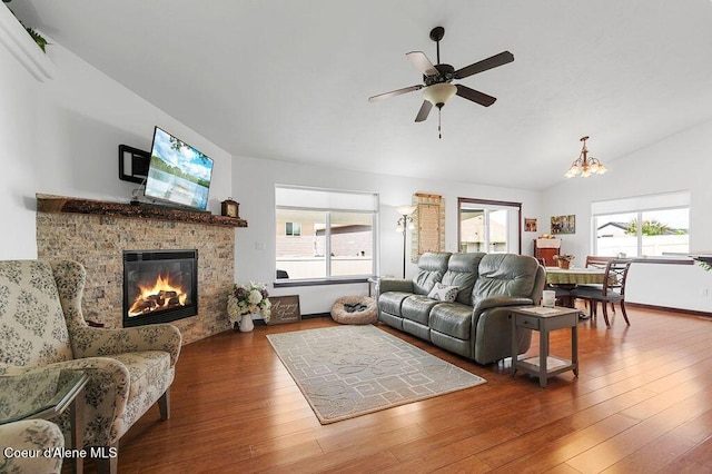 6487 W Covenant St, Rathdrum, ID 83858 - living room featuring a glass covered fireplace, vaulted ceiling, wood finished floors, a ceiling fan, and a chandelier