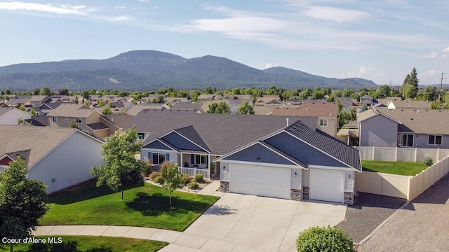 6487 W Covenant St, Rathdrum, ID 83858 - view of front of property featuring a garage, a residential view, stone siding, concrete driveway, and a mountain view