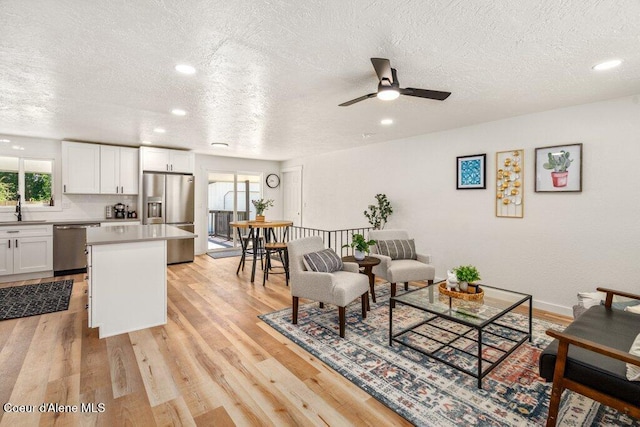 320 E Dakota Ave, Hayden, ID 83835 - living room with healthy amount of natural light, a textured ceiling, light wood-type flooring, a ceiling fan, and recessed lighting