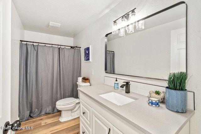 320 E Dakota Ave, Hayden, ID 83835 - bathroom with vanity, wood finished floors, tasteful backsplash, and curtained shower