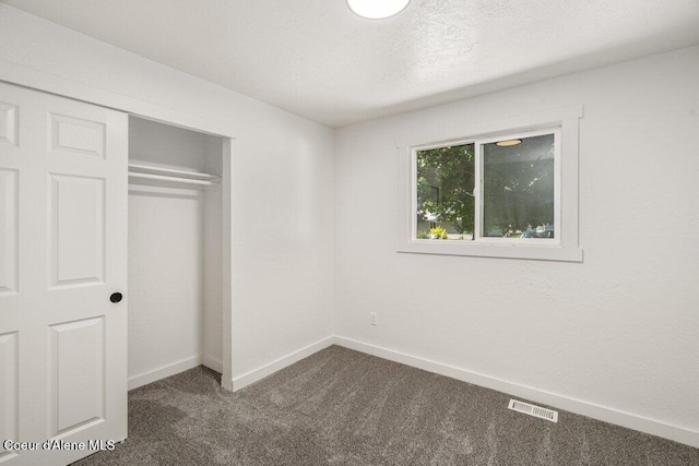 320 E Dakota Ave, Hayden, ID 83835 - unfurnished bedroom featuring dark colored carpet and a closet