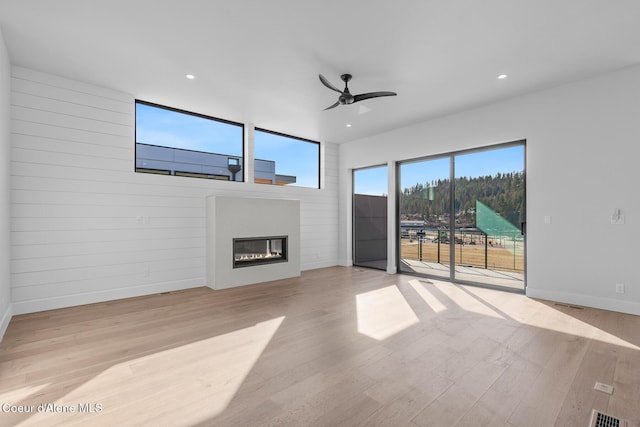 2492 N Atlas Rd, Coeur Dalene, ID 83814 - unfurnished living room with a glass covered fireplace, light wood-style flooring, ceiling fan, and recessed lighting