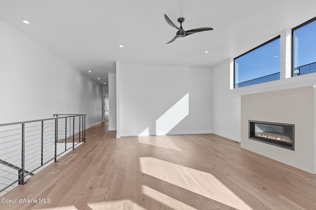 2492 N Atlas Rd, Coeur Dalene, ID 83814 - unfurnished living room featuring wood finished floors, a ceiling fan, a fireplace, recessed lighting, and wooden walls