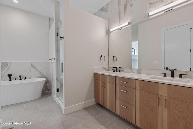 2492 N Atlas Rd, Coeur Dalene, ID 83814 - bathroom featuring double vanity, a freestanding bath, tile walls, tile patterned floors, and a wainscoted wall
