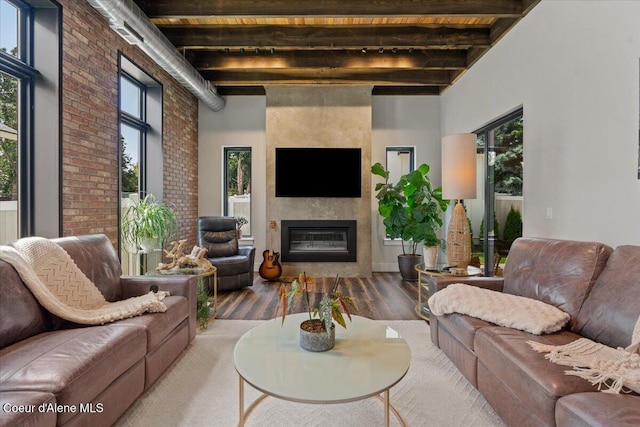 9137 N Raintree Ln, Hayden, ID 83835 - living room featuring beamed ceiling, healthy amount of natural light, wood finished floors, a fireplace, and brick wall