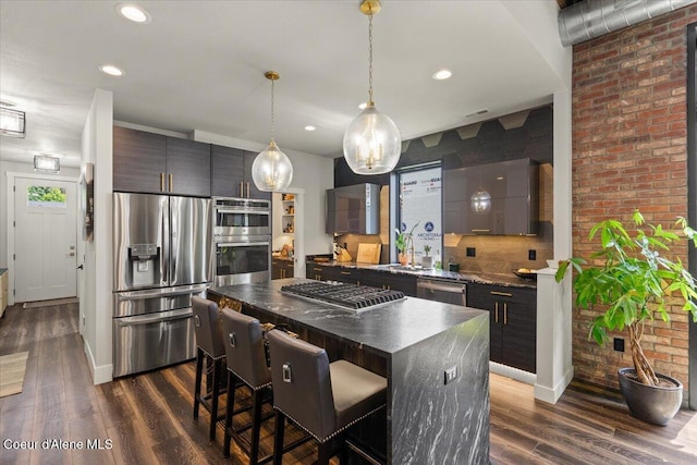 9137 N Raintree Ln, Hayden, ID 83835 - kitchen featuring appliances with stainless steel finishes, dark countertops, a kitchen bar, modern cabinets, and dark wood-type flooring