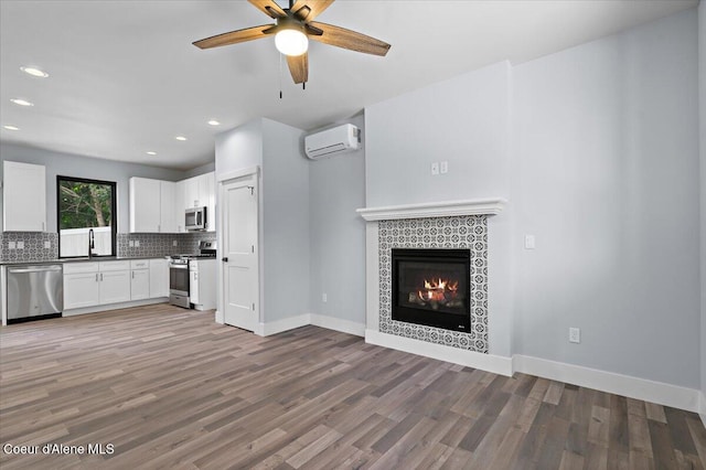 9137 N Raintree Ln, Hayden, ID 83835 - kitchen featuring stainless steel appliances, a wall mounted air conditioner, open floor plan, wood finished floors, and backsplash