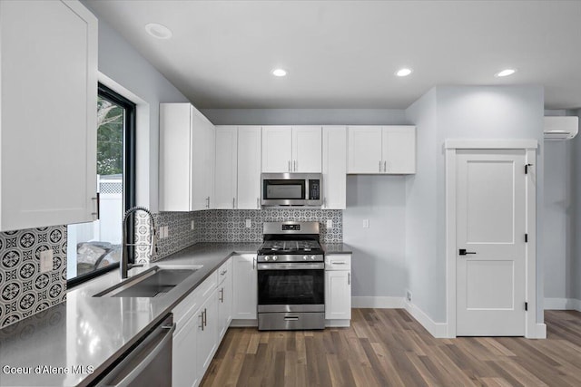 9137 N Raintree Ln, Hayden, ID 83835 - kitchen with stainless steel appliances, a wall unit AC, white cabinetry, tasteful backsplash, and recessed lighting