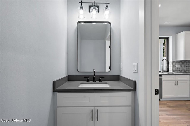 9137 N Raintree Ln, Hayden, ID 83835 - bathroom featuring two vanities, wood finished floors, and tasteful backsplash