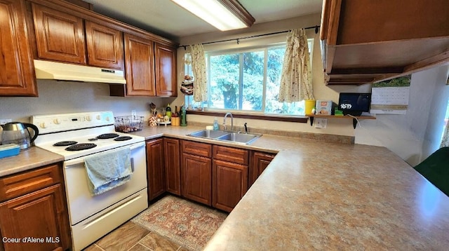 1150 Elm Dr, Saint Maries, ID 83861 - kitchen featuring white range with electric cooktop, under cabinet range hood, light countertops, and brown cabinets