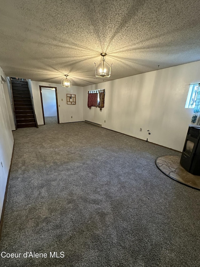 1150 Elm Dr, Saint Maries, ID 83861 - unfurnished room with stairs, carpet flooring, a wood stove, a textured ceiling, and a baseboard heating unit